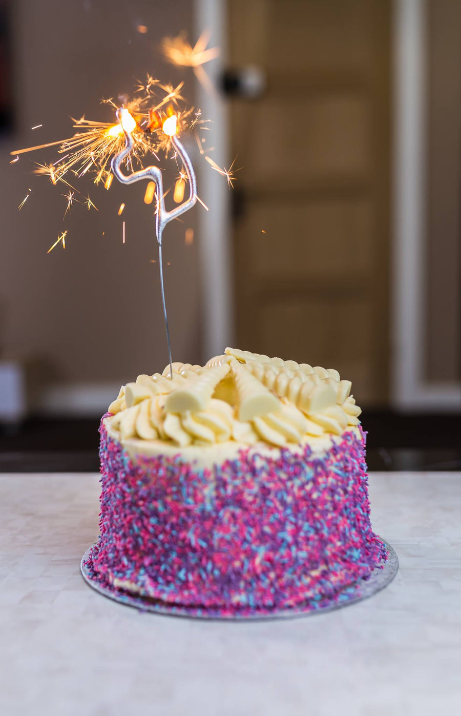 Premium AI Image | A birthday cake with lit candles is lit with sparklers  in the background.